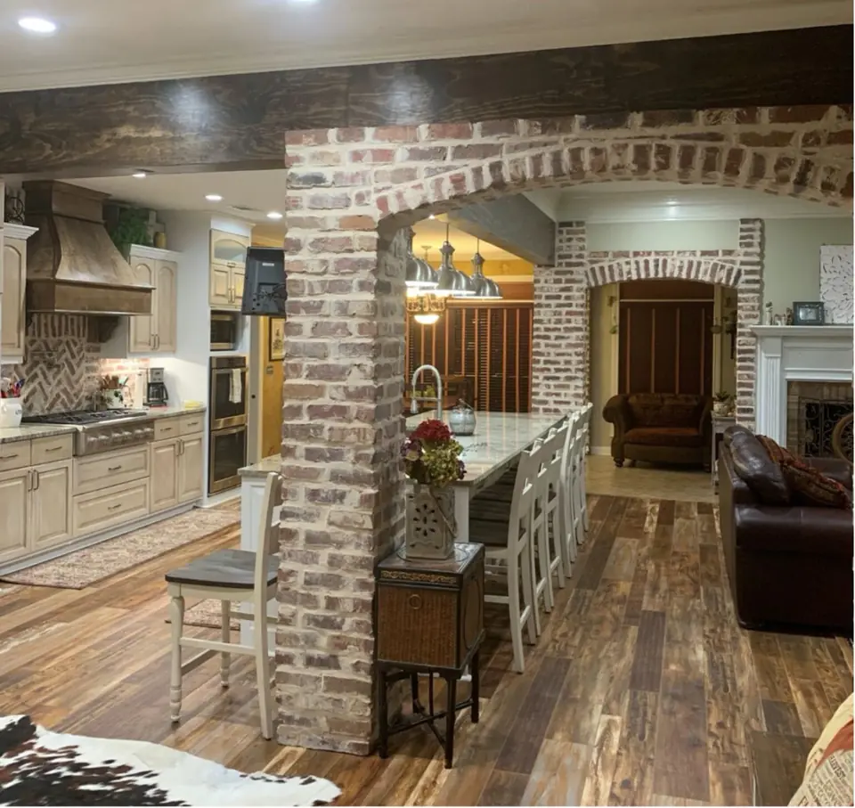 Kitchen with a reclaimed brick column and arched opening