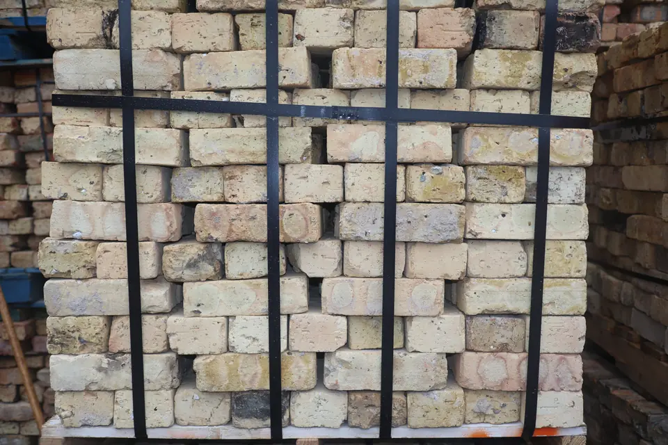 Pallet of light cream and buff reclaimed Chicago brick, banded and stacked