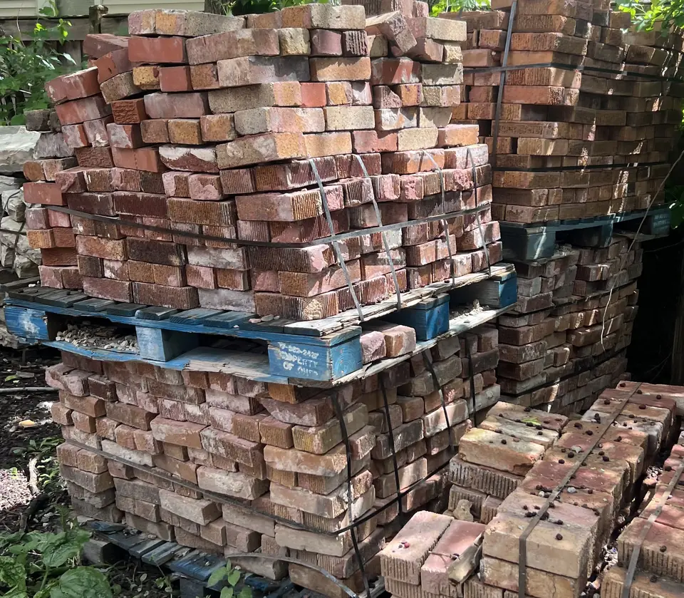 Pallets of reclaimed brick in shades of red, orange and pink